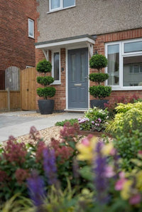 Showcase · Pair of three-tiered cloud-pruned privet in charcoal pots flanking a slate-blue front door
