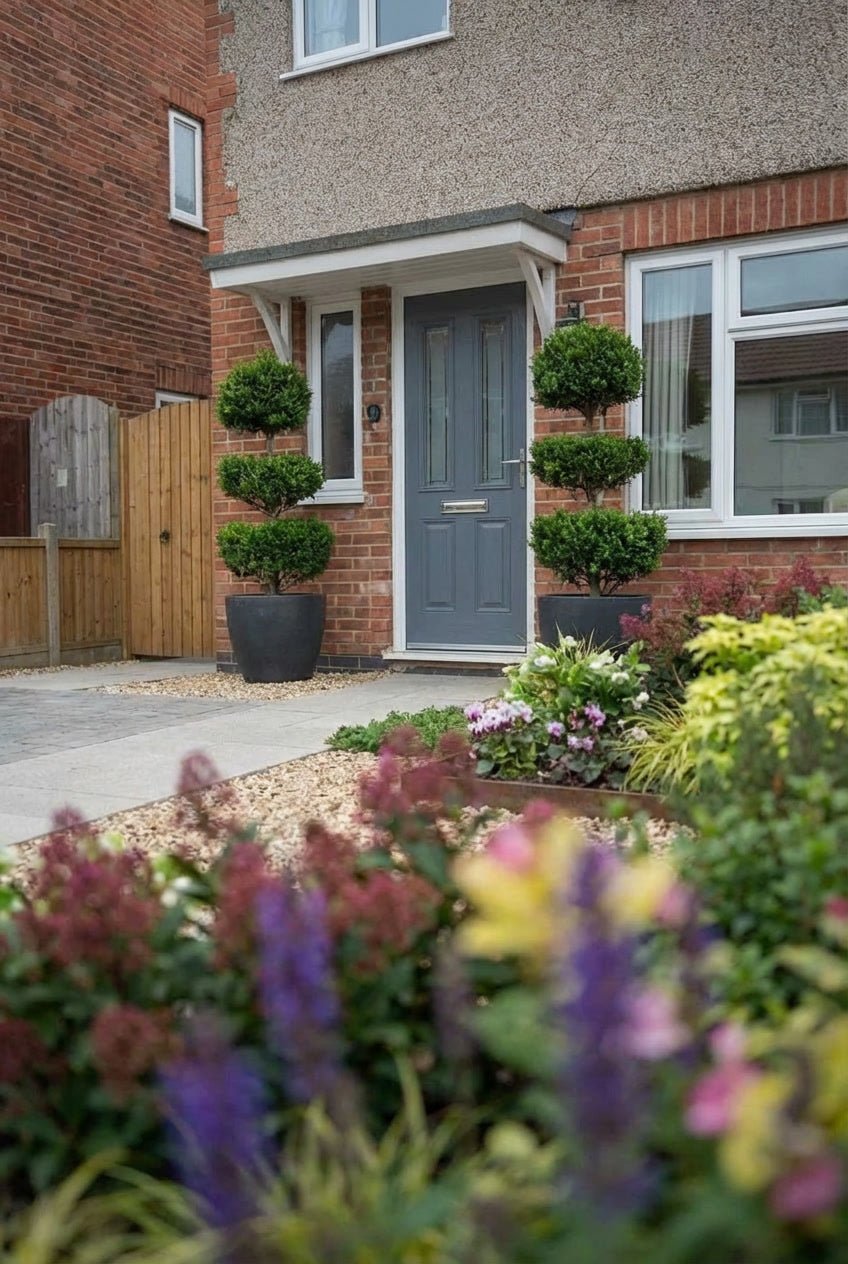 Showcase · Pair of three-tiered cloud-pruned privet in charcoal pots flanking a slate-blue front door
