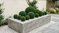 Showcase · Wide view of the sphere gradient planter between white gravel and grey paving