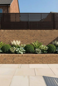 Showcase · Yew balls, white astilbe, ferns and hellebores planted along a brick raised bed