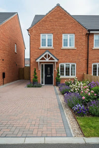 Showcase · New-build seen from the pavement, spiral topiary at the door and a rose and lavender bed alongside