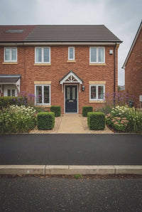 Showcase · Four matched cubes framing the path to a navy front door, prairie planting either side