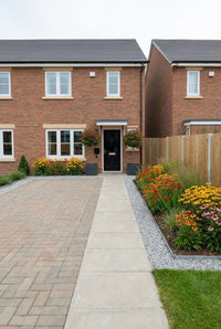 Showcase · New-build frontage with photinia standards at the door and a border of rudbeckia and crocosmia