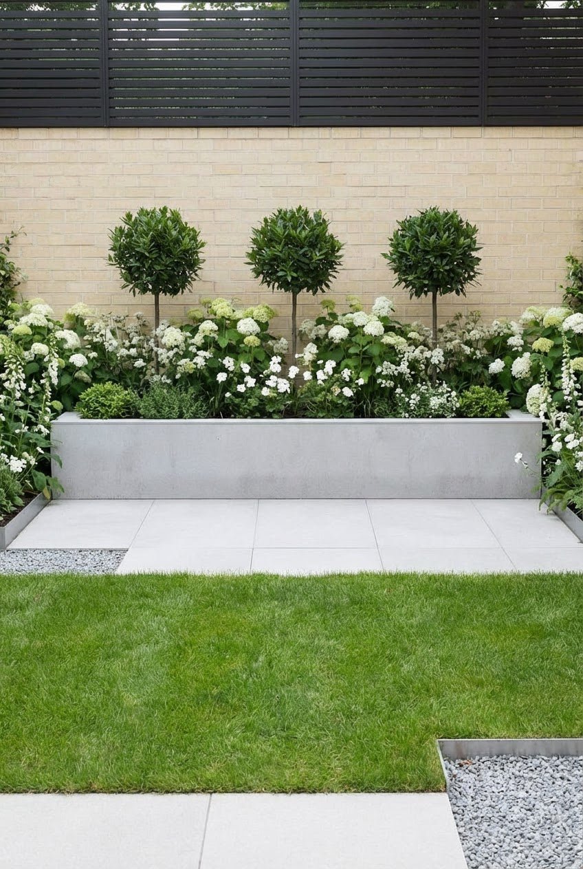 Showcase · Three bay lollipops above white hydrangeas and foxgloves in a long grey planter