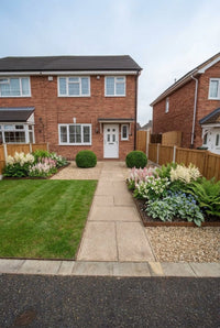 Showcase · House frontage with a pair of yew balls flanking the door and a shady border of ferns and astilbe